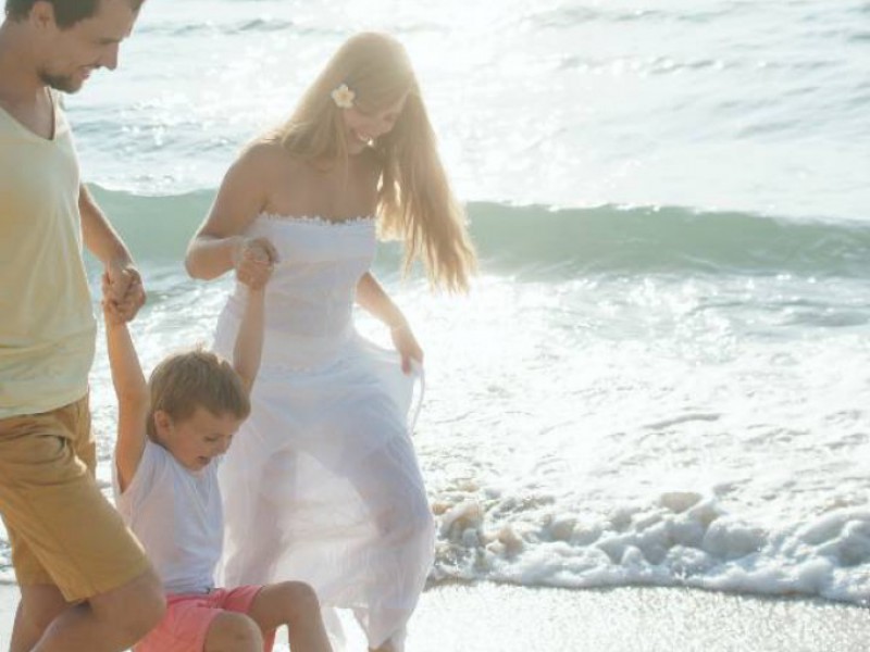 Famille heureuse se promenant au bord de la mer.