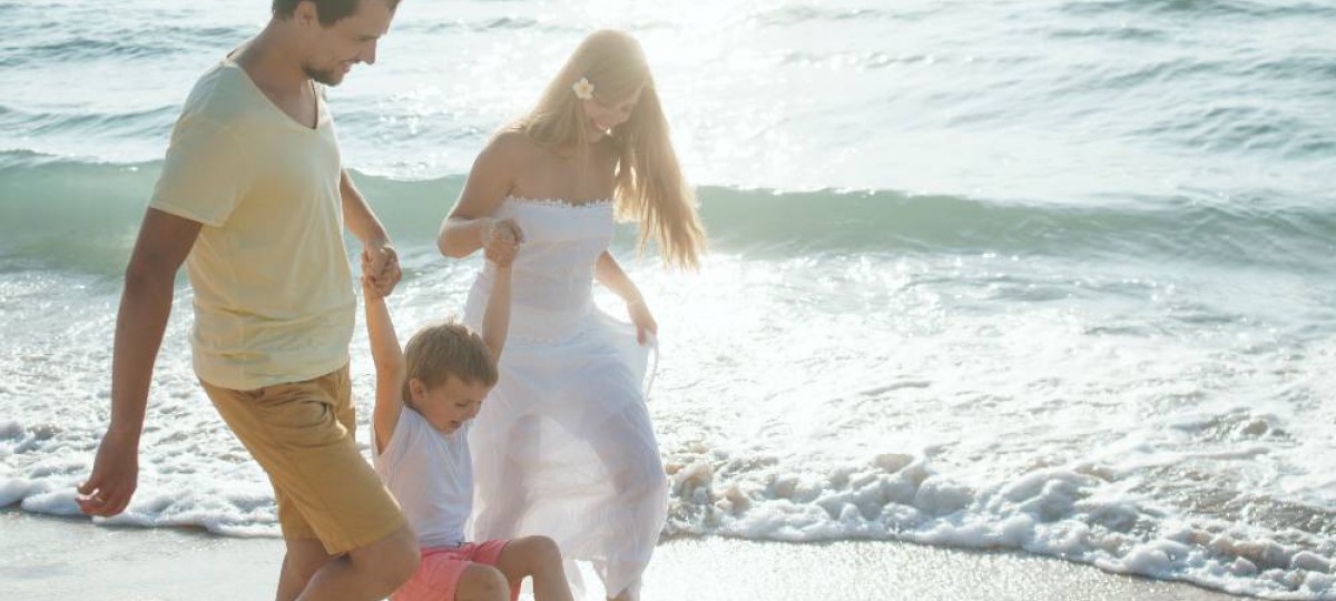 Famille heureuse se promenant au bord de la mer.