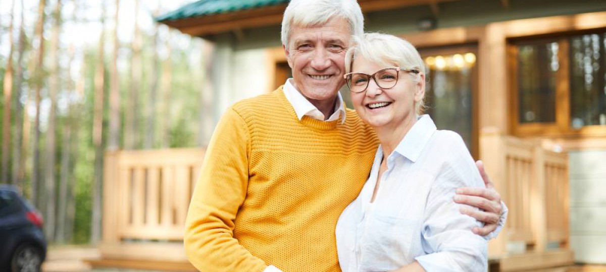 couple senior devant sa nouvelle maison