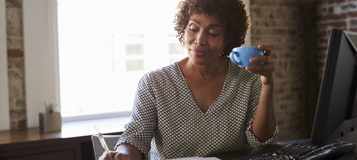 Une dame boit un café en attendant d'avoir une réponse à sa demande de rachat de crédits