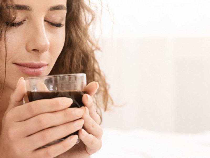 Une dame boit son café en pensant à demander une trésorerie supplémentaire avec son rachat de crédits