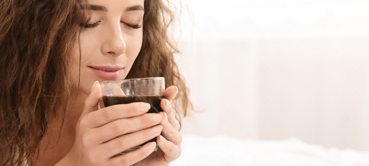 Une dame boit son café en pensant à demander une trésorerie supplémentaire avec son rachat de crédits