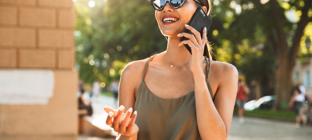 Une dame sourit au téléphone, elle vient de signer un rachat de crédits