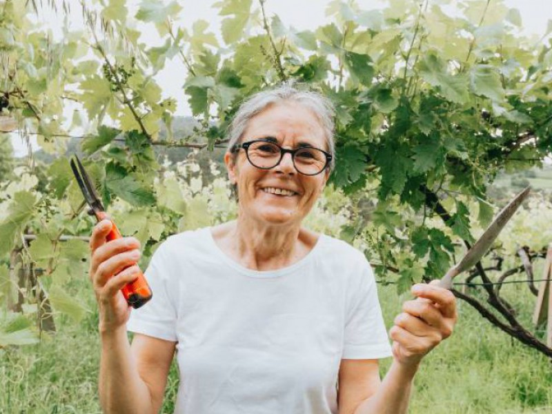 femme à la retraite qui jardine heureuse d'avoir découvert les avantages du rachat de crédits