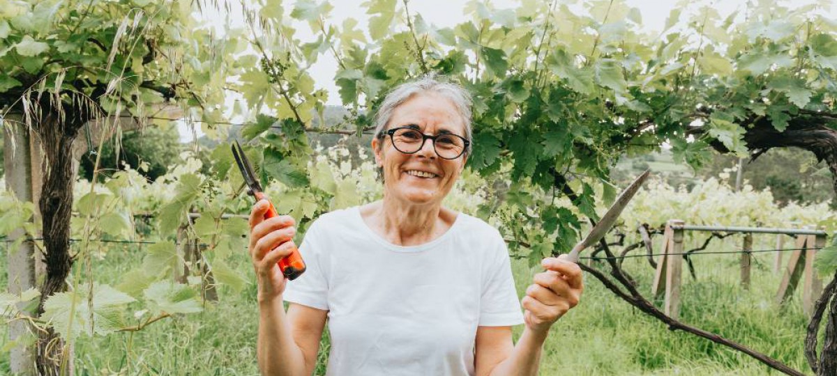 femme à la retraite qui jardine heureuse d'avoir découvert les avantages du rachat de crédits