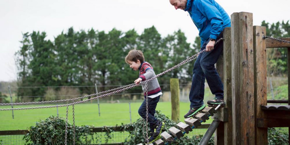 Père et son fils qui s'amusent sur un pont suspendu en bois