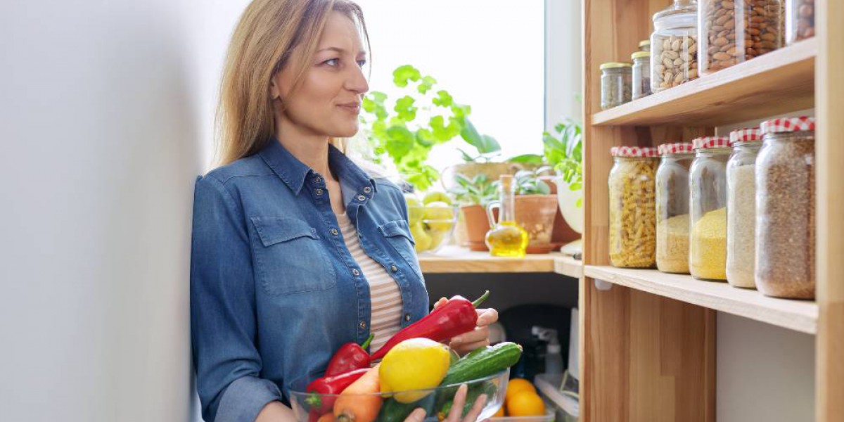 femme devant son étagère à bocaux avec légumes dans les bras