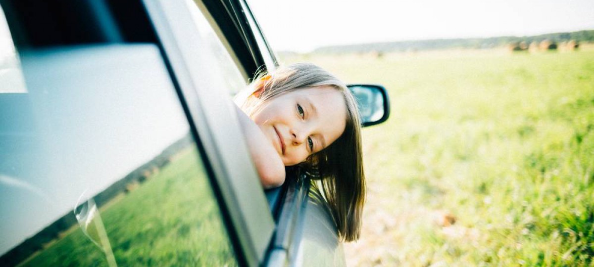 Petite fille passant la tête par la fenêtre d'une voiture dont la LOA a été regroupée avec un rachat de crédits