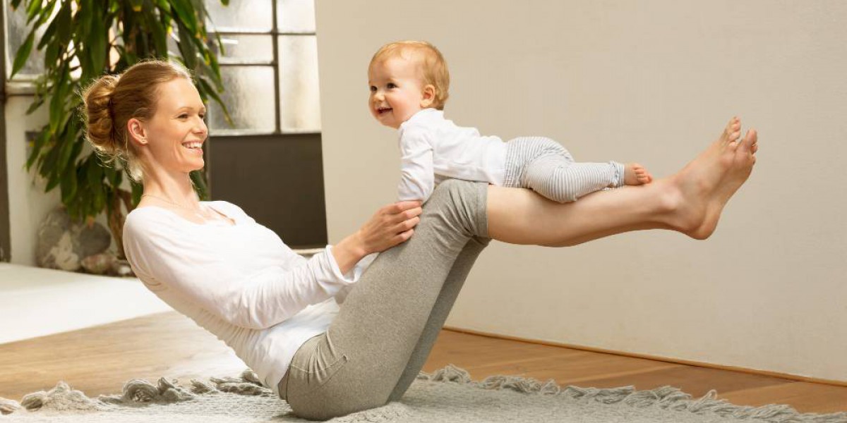 mère assise en équilibre au sol avec son bébé sur les jambes