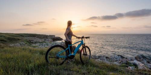 femme seule avec son velo eletrique admirant le paysage