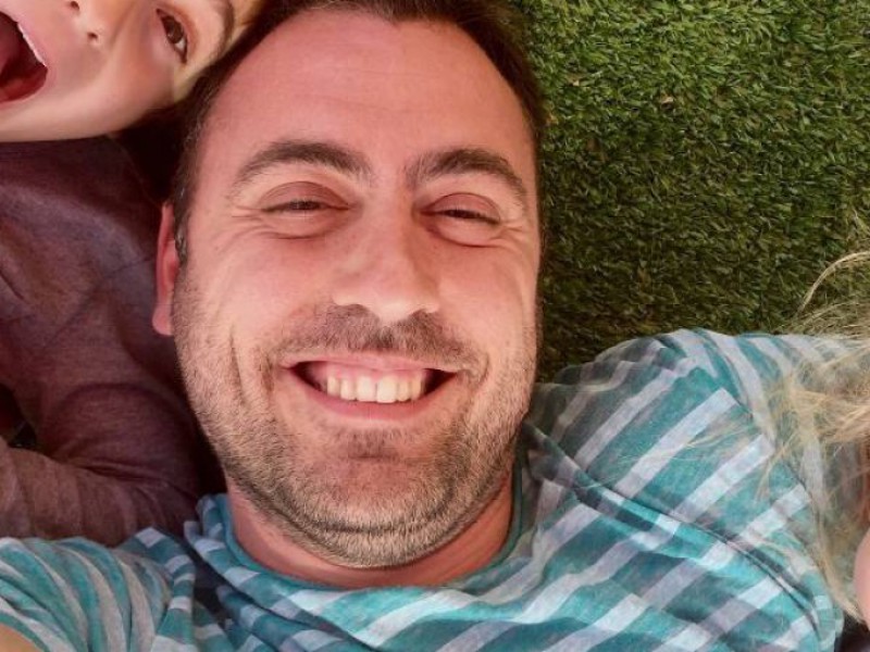 selfie d'un papa et ses deux enfants allongés dans l'herbe