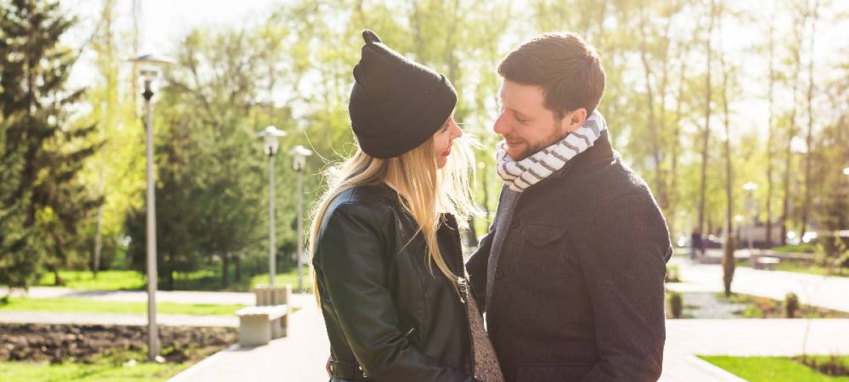 Couple dont femme enceinte heureux dans un parc