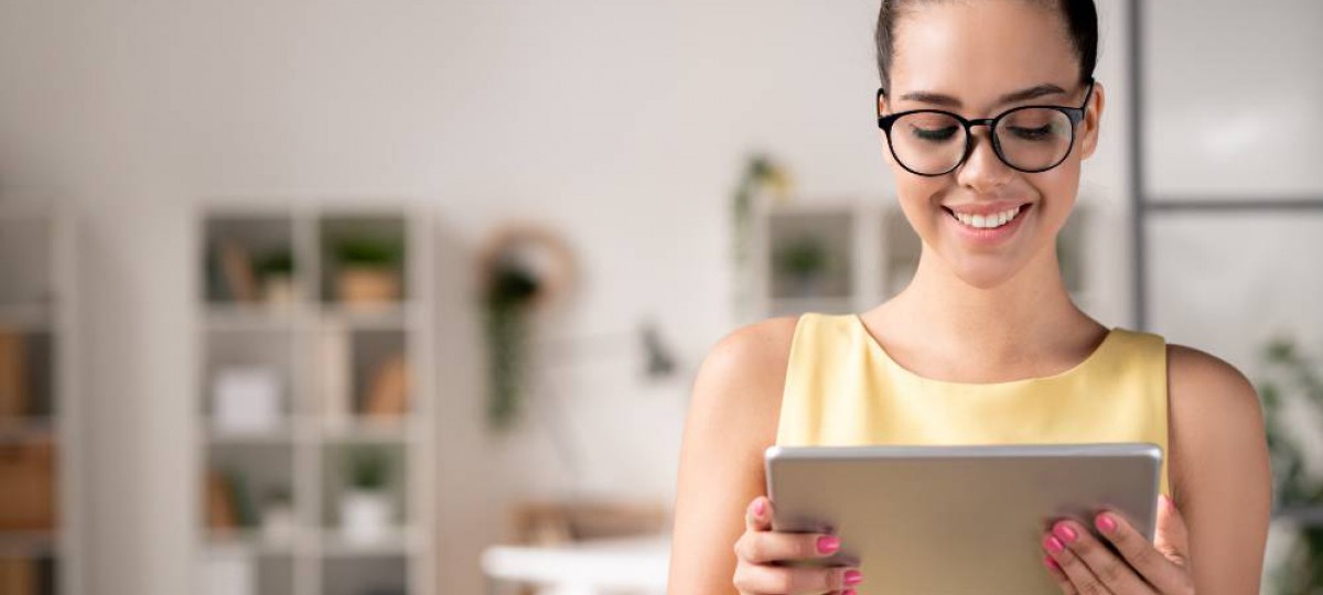 femme avec des lunettes lisant notre article sur sa tablette