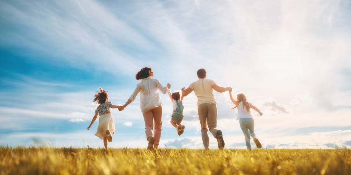 Famille heureuse courant dans un champs au soleil