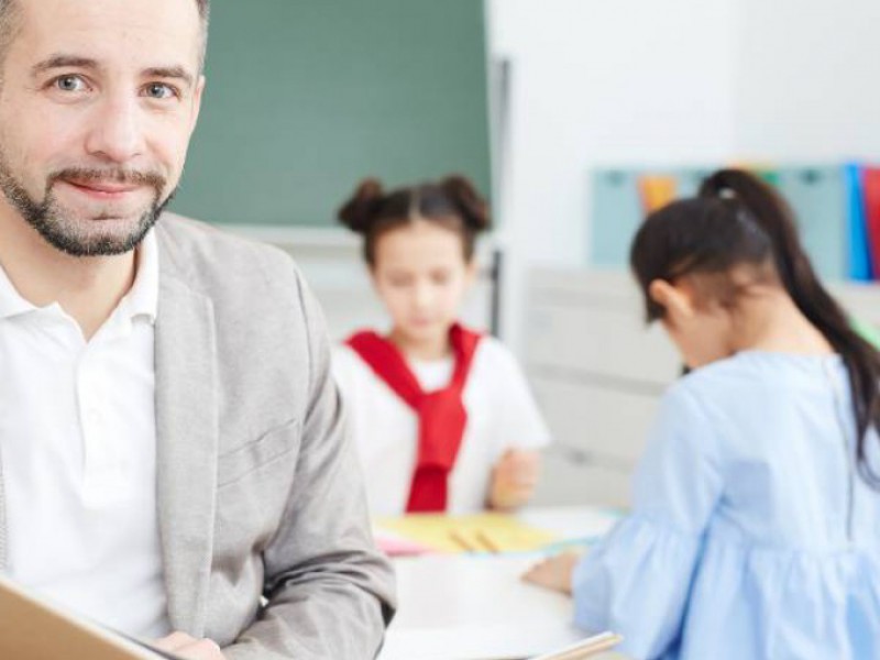 Enseignant tenant un livre devant sa classe