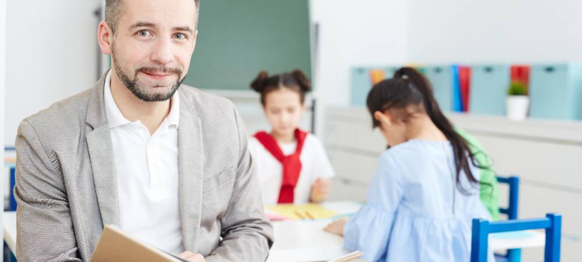 Enseignant tenant un livre devant sa classe