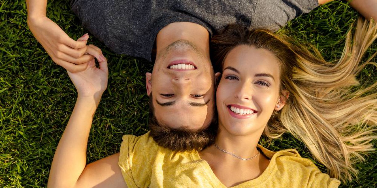 Couple heureux et souriant allongé dans l'herbe
